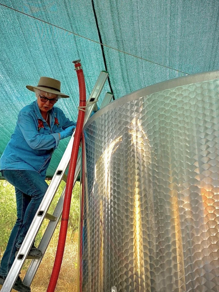 Female winemaker near tank